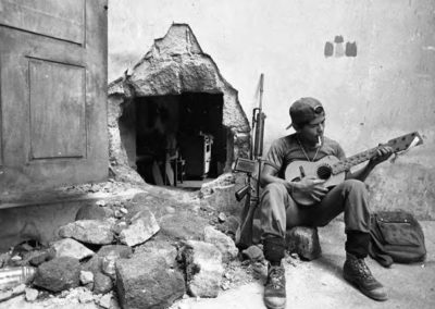 A man playing guitar by the fire place