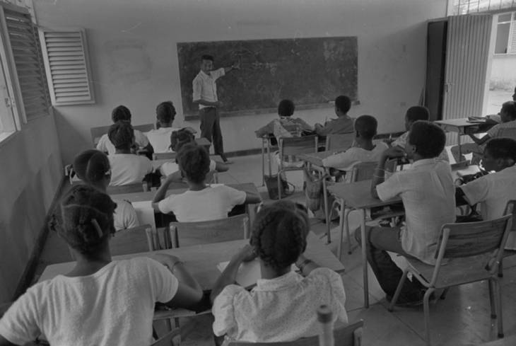 Teenagers and children in a classroom with teacher