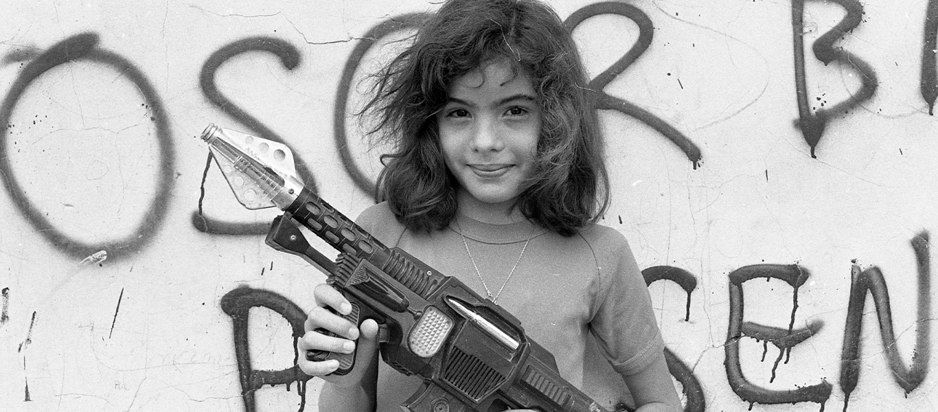 little girl holding a rifle smiling