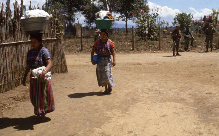 Mayan women carry basket of clothing on their heads,