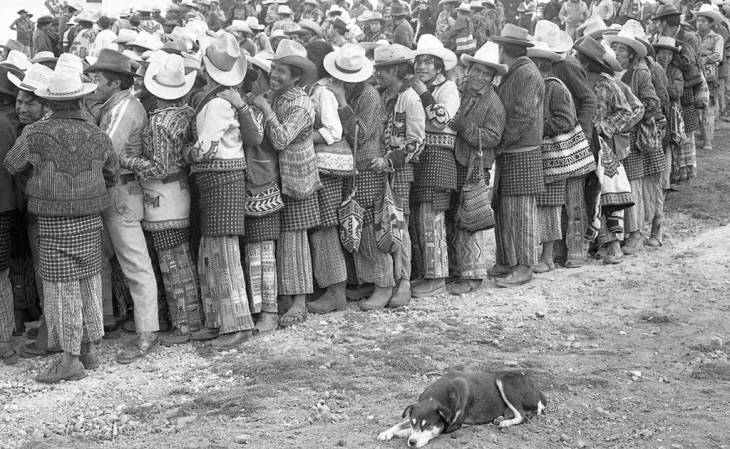 Mayan men waiting in line to vote