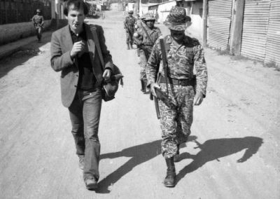 a man and a soldier walking side by side in a town